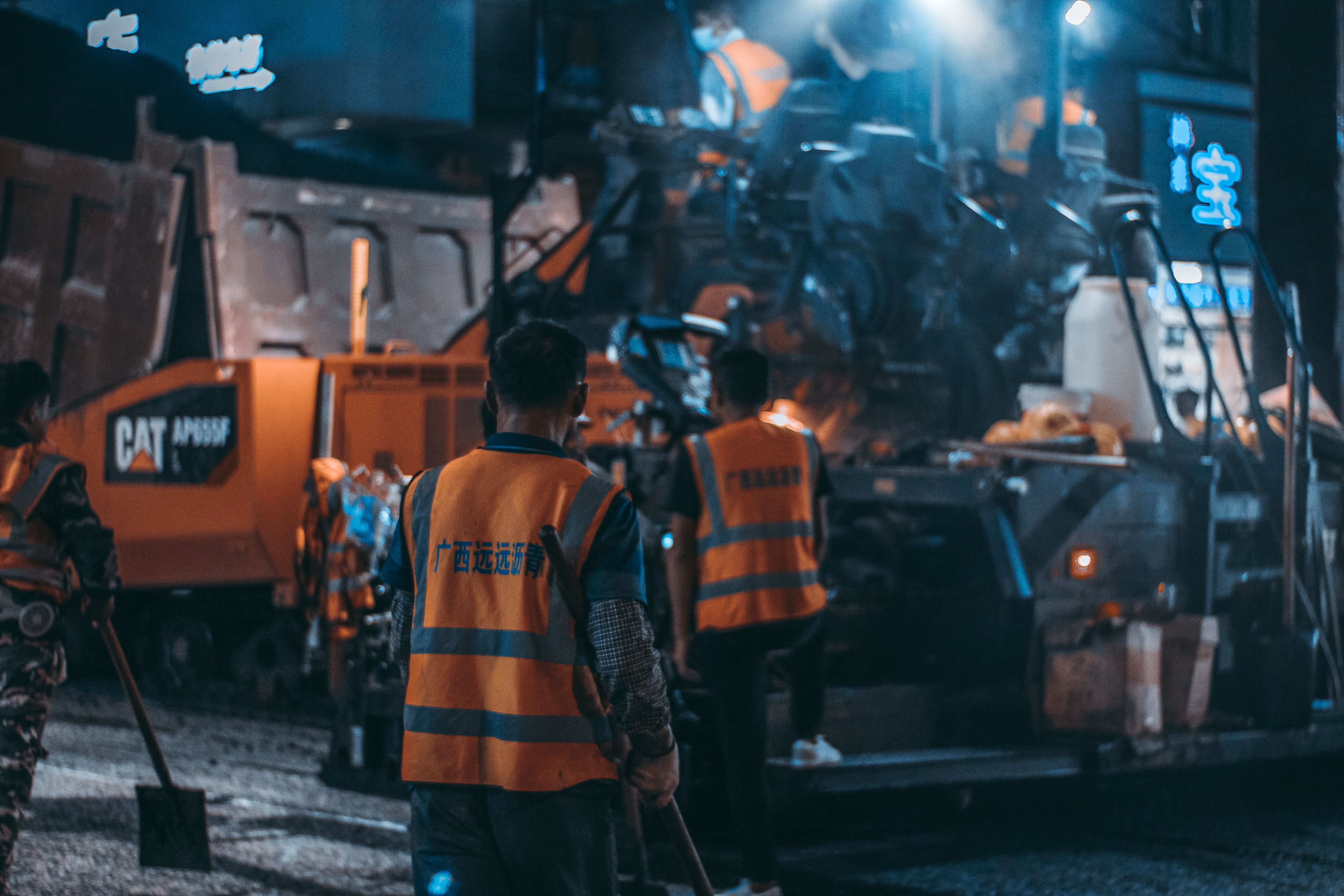 Construction workers collaborating on site with heavy machinery